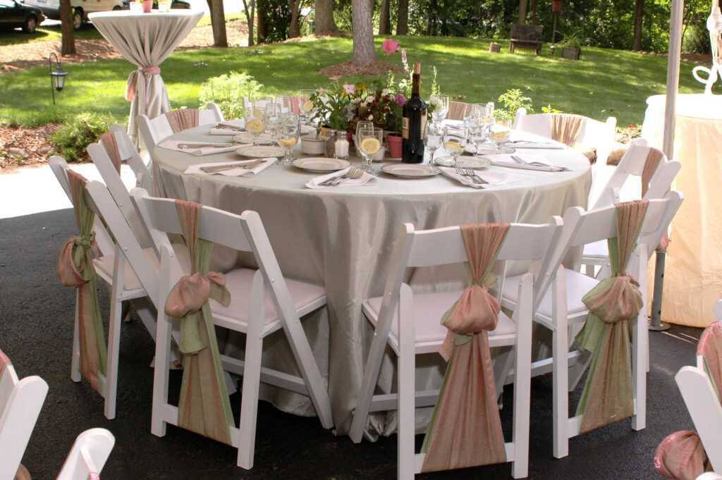 outdoor wedding decor with white chairs and natural plants