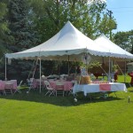 small tent with tables and chairs and other supplies on graduation party checklist