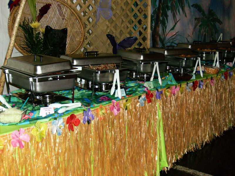 beach themed event with chafing dishes and grass table skirt